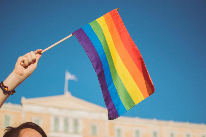 Bandera trans en un banderín sostenida