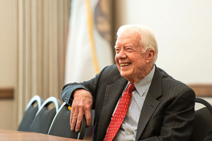 Jimmy Carter sentado sonriendo durante el año 2013.