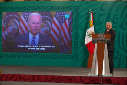 El presidente de México habla con una imagen de Joe Biden de fondo.