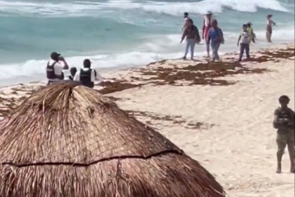 Miembros de la Policía vigilan una playa de Cancún.