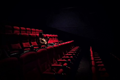 Imagen de una mujer sentada sola en uno de los cines estadounidenses. La taquilla registró el fin de semana del 22 de septiembre la peor recaudación en lo que va de año.