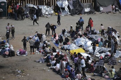 Migrantes atrapados entre las vallas primaria y secundaria en la frontera entre Tijuana y San Diego, visto desde Tijuana, México.