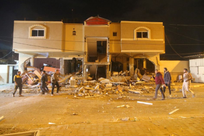 Palestinos inspeccionan las ruinas de una casa tras un ataque aéreo israelí antes del amanecer del 9 de mayo de 2023.