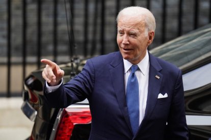 El presidente Joe Biden señala un coche mientras camina.
