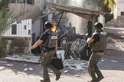 Dos soldados contemplando un edificio destruido tras la llegada de varios misiles desde Gaza a Israel, iniciando la guerra.