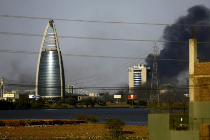 La imagen muestra la ciudad de Khartoum, capital de Sudán. Cerca de un edificio moderno, una columna de humo se eleva.