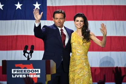 Ron DeSantis junto a su mujer en un atril frente a la bandera Norteamericana.