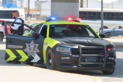 Un policía de San Luis de Potosí sale de su coche patrulla.