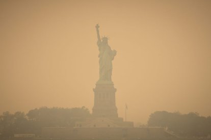 Imagen de la Estatua de la Libertad, en Nueva York, teñida de naranja a consecuencia de la nube tóxica proveniente de Canadá que empeoró la calidad del aire.