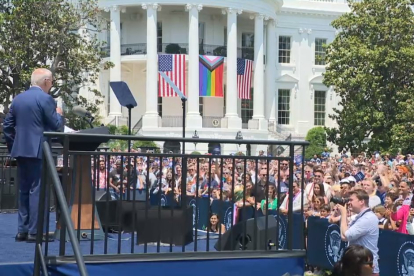 Biden habla a sus seguidores ante una bandera LGBT gigante en la Casa Blanca.