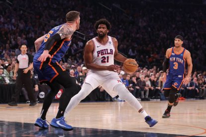 30 de abril de 2024; Nueva York, Nueva York, EE.UU.; El pívot de los Philadelphia 76ers Joel Embiid (21) controla el balón contra el pívot de los New York Knicks Isaiah Hartenstein (55) y el escolta Josh Hart (3) durante el primer cuarto de la primera ronda de los playoffs de la NBA 2024 en el Madison Square Garden