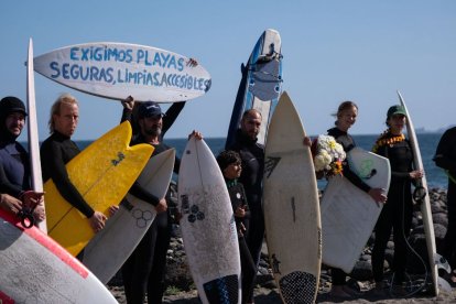 Surfistas de pie antes de participar en una ceremonia en honor de dos australianos y un surfista estadounidense que desaparecieron la semana pasada durante un viaje de surf en la playa de San Miguel en Ensenada, estado de Baja California, México, el 5 de mayo de 2024.