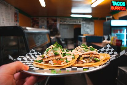 Imagen de archivo de un camarero de un restaurante mexicano sirviendo burritos.