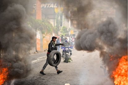 Un manifestante quema neumáticos durante una manifestación que pedía la dimisión del primer ministro Ariel Henry en Puerto Príncipe el 7 de febrero de 2024.