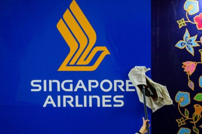 (ARCHIVO) Un trabajador limpia un logotipo de Singapore Airlines en la Feria Internacional de Turismo (ITB, Internationale Tourismusboerse) de Berlín el 6 de marzo de 2023. Singapore Airlines dijo el 21 de mayo de 2024 que una persona murió y otras resultaron heridas tras una "turbulencia severa" en un vuelo procedente de Londres que realizó un aterrizaje de emergencia en Bangkok.