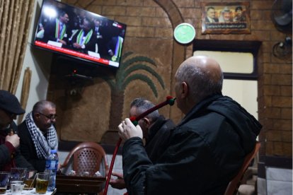 Unos hombres sentados en un café ven en un televisor cómo el máximo tribunal de la ONU en La Haya lee su decisión inicial en un caso en el que se acusa a Israel de genocidio,