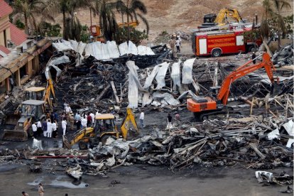 Funcionarios limpian los restos carbonizados en el lugar del incendio ocurrido  en las instalaciones de un parque de atracciones en Rajkot, en el estado indio de Gujarat, el 26 de mayo de 2024.