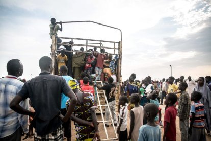 Personas que huyen de la guerra sudanesa desembarcan de un camión que las ha traído a Renk desde el paso fronterizo de Joda, en Sudán del Sur.