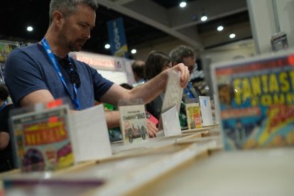 A person browses comic books on the first day of Comic-Con International at the San Diego Convention Center in San Diego, California, on July 24, 2024. (Photo by Chris DELMAS / AFP)