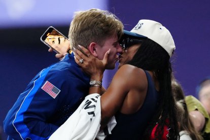 Gold medallist US' Hunter Woodhall (L) celebrates with his wife Olympic women's long jump champion Tara Davis-Woodhall after the victory ceremony for the Men's 400m T62 final event at the Stade de France in Saint-Denis, outside Paris on September 6, 2024. (Photo by Dimitar DILKOFF / AFP)