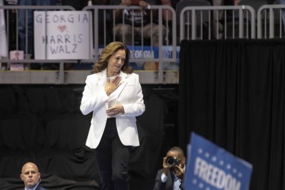 Kamala Harris agradece los gritos de apoyo de los asistentes a un acto de campaña mientras sube al escenario.