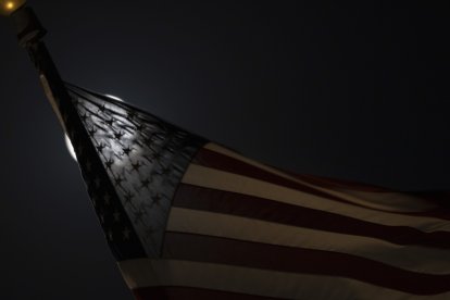 September 17, 2024, Fort Worth, Texas, United States: Sept. 17, 2024. The Super harvest moon passes thru a partial lunar eclipse behind an American flag waving over the Amon Carter Museum in Fort Worth, Tx. (Credit Image: © Ralph Lauer/ZUMA Press Wire)