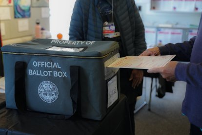 Elecciones presidenciales 2024: Un votante introduce su papeleta en la urna oficial en uno de los centros de votación anticipada de San Diego.