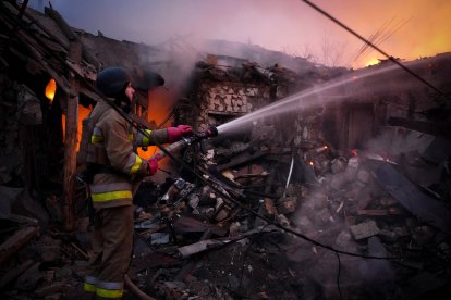 Un rescatista ucraniano trabaja para extinguir un incendio luego de un ataque con drones rusos