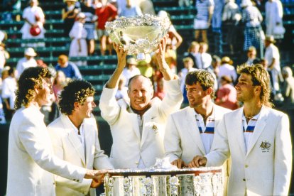 El entrenador Neale Fraser levanta el trofeo con los jugadores mirando