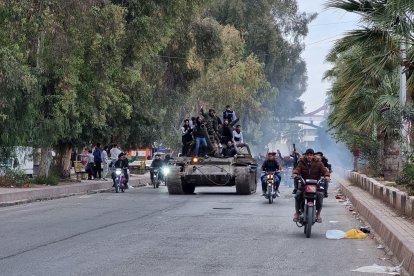 Varias personas viajan en un tanque en la ciudad de Daraa, en el sur de Siria, el 7 de diciembre de 2024, después del colapso de las fuerzas gubernamentales.