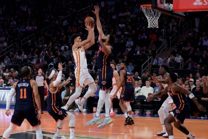 Zaccharie Risacher (10), alero de los Atlanta Hawks, conduce hacia la canasta contra Karl-Anthony Towns