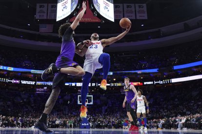 El jugador de los Philadelphia 76ers Eric Gordon, a la derecha, lanza a canasta contra Jaxson Hayes