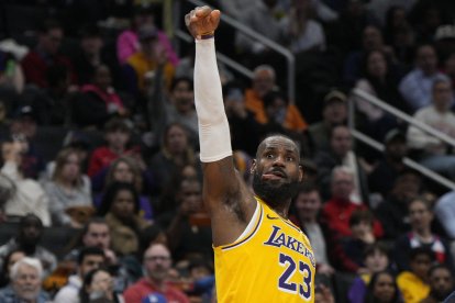 El alero de los Lakers de Los Ángeles LeBron James celebra una canasta de 3 puntos contra los Wizards de Washington durante la segunda parte de un partido de baloncesto de la NBA.