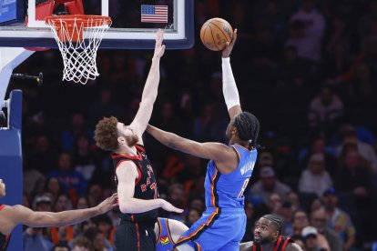 Jalen Williams lanza para los Thunder mientras el alero de los Toronto Raptors Garrett Temple defiende.