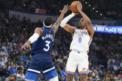 El alero de Oklahoma City Thunder Jalen Williams (8) lanza sobre el alero de Minnesota Timberwolves Jaden McDaniels (3) durante la primera parte de un partido de baloncesto de la NBA.