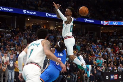 El escolta de los Memphis Grizzlies Ja Morant (12) pierde el control del balón al recibir una falta del escolta de los Oklahoma City Thunder Luguentz Dort (5) durante el segundo cuarto del tercer partido de la primera ronda de los Playoffs 2024 de la NBA en el FedExForum.