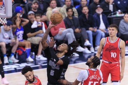 Stephon Castle #5 de los San Antonio Spurs intenta un tiro de dos puntos mientras Derrick Jones Jr. #55 y Ben Simmons #25 de Los Angeles Clippers defienden durante su partido de temporada regular de la NBA el martes 8 de abril de 2025 en el Intuit Dome en Inglewood, California. Los Clippers derrotan a los Spurs por 122-117.