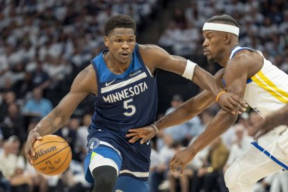8 de mayo de 2025; Minneapolis, Minnesota, EE.UU.; El escolta de los Minnesota Timberwolves Anthony Edwards (5) regatea el balón ante el alero de los Golden State Warriors Jimmy Butler III (10) en la primera parte del segundo partido de la segunda ronda de los Playoffs de la NBA 2025 en el Target Center.