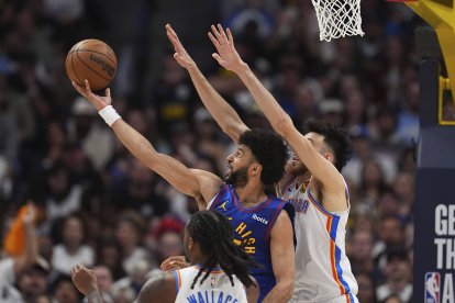 El escolta de los Nuggets de Denver Jamal Murray, atrás a la izquierda, sube a canasta mientras el escolta de los Thunder de Oklahoma City Cason Wallace, delante, y el alero Chet Holmgren defienden en la segunda mitad del tercer partido de las semifinales de la Conferencia Oeste de los playoffs de baloncesto de la NBA, el viernes 9 de mayo de 2025, en Denver.