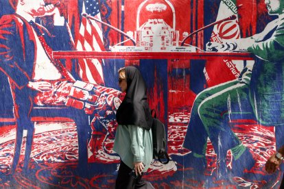 Una mujer pasa junto a un mural cerca de la antigua embajada de EEUU en Teherán