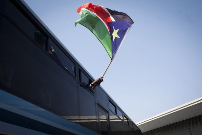 Un refugiado de Sudán del Sur ondea su bandera nacional