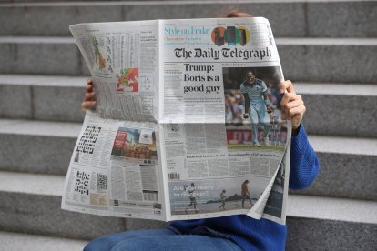 Un lector hojea un ejemplar de The Telegraph