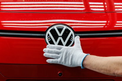 Un empleado prepara un coche en la cadena de montaje del Volkswagen
