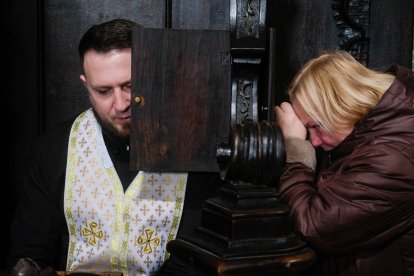 Un sacerdote se confiesa durante la misa en la Iglesia de los Santísimos Apóstoles Pedro y Pablo. Se celebra una misa en la Iglesia de los Santísimos Apóstoles Pedro y Pablo. Días antes tuvo lugar el funeral de tres soldados ucranianos muertos durante el combate. A 30 kilómetros, misiles rusos alcanzaron una base militar matando a 35 soldados.