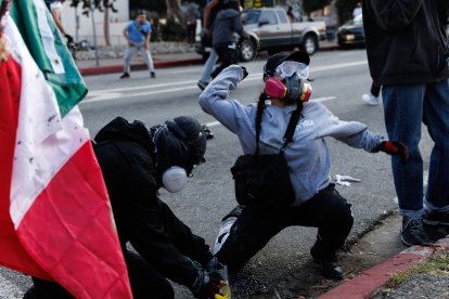 Esta foto tomada el 8 de junio de 2025 muestra a manifestantes lanzando tinta a los agentes de la Patrulla de Carreteras de California durante una manifestación tras las operaciones federales de inmigración en Los Ángeles.