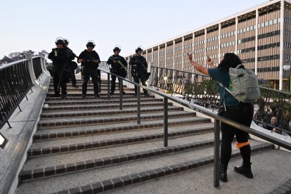El 10 de junio de 2025, una manifestante hace un gesto grosero a los agentes de la policía de Los Ángeles cuando tiene que desalojar la zona tras la entrada en vigor del toque de queda después de varios días de protestas en respuesta a las operaciones federales de inmigración en Los Ángeles. El 10 de junio entró en vigor un toque de queda nocturno en el centro de Los Ángeles, golpeado por las protestas. La alcaldesa, Karen Bass, había declarado anteriormente que el objetivo era "detener el vandalismo y los saqueos" tras varios días de disturbios.