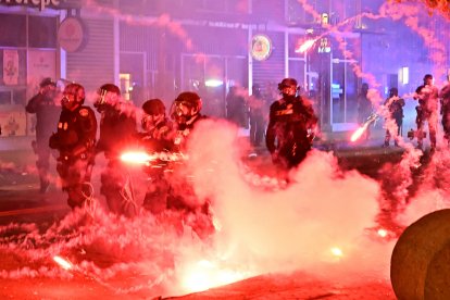 Fuegos artificiales explotan alrededor de agentes de policía con equipo antidisturbios durante una protesta en respuesta a las operaciones federales de inmigración en el barrio de Little Tokyo, en el centro de Los Ángeles, el 9 de junio de 2025. La administración del presidente Donald Trump dijo el 9 de junio que enviaba 700 marines estadounidenses y miles de efectivos más de la Guardia Nacional a Los Ángeles, lo que provocó una furiosa respuesta del gobernador de California por el "desquiciado" despliegue. Las protestas en Los Ángeles, hogar de una gran población latina, estallaron el 6 de junio, desencadenadas por redadas de inmigración que se saldaron con decenas de detenciones de lo que las autoridades dicen que son migrantes ilegales y miembros de bandas.
