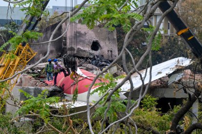 Operarios trabajan para quitar los restos del avión siniestrado