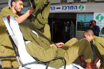 Un soldado israelí herido se cubre la cara al llegar al hospital Beershevas Soroka tras la explosión de un jeep del ejército en el paso fronterizo de Kissufim, entre Israel y la Franja de Gaza, el 27 de enero de 2009, en la que murió un soldado y otros tres resultaron heridos.