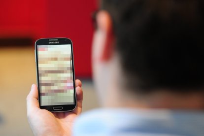 Una persona viendo un teléfono con contenido censurado